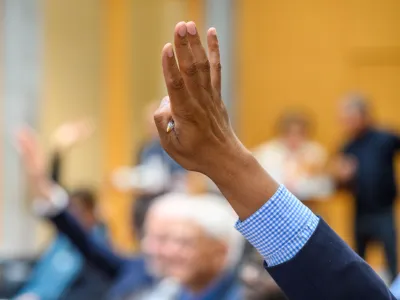 A hand being raised during a session at the Richard von Weizsäcker Forum